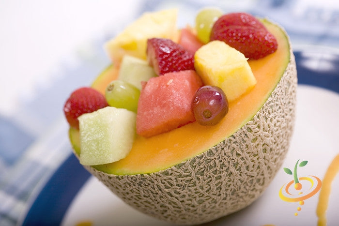 Honey Rock seeds cantaloupe melon half filled with mixed fruit salad including strawberries, grapes, pineapple, and watermelon chunks