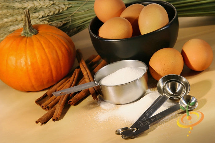 Small Sugar pumpkin with eggs, cinnamon sticks, and measuring spoons for baking ingredients